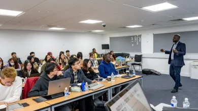 Students seated at tables watching presenter
