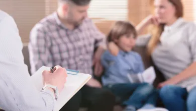 A therapist take notes while interviewing a family