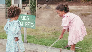 Two children gardening at a kids' veggie patch.
