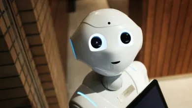 Head and shoulders of a robot with large eyes looking at the camera