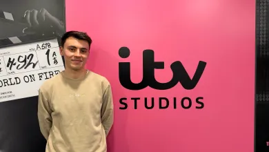 BA Spanish and Linguistics Graduate, Joe Dobinson standing by a sign for ITV studios.