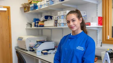 Amelia Milkins standing in front of shelves in the lab