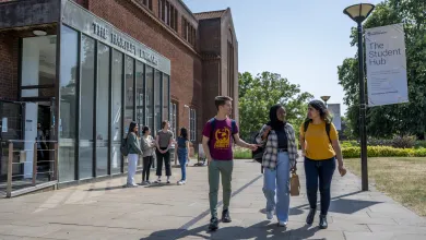 Three students walking past the Hartley Library