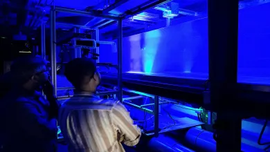 Researchers observing illuminated airflow patterns during an experimental fluid mechanics test