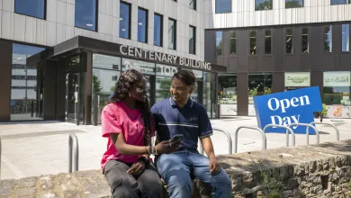 Two students sat outside the Centenary Building on Highfield campus.