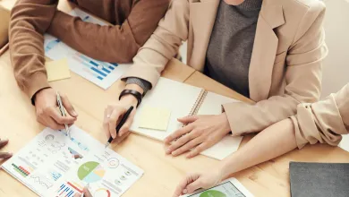 A group of people sitting at a table working on papers