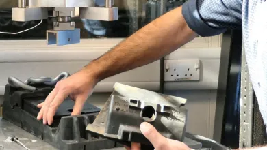 Researcher preparing a component for testing in a laboratory materials testing machine
