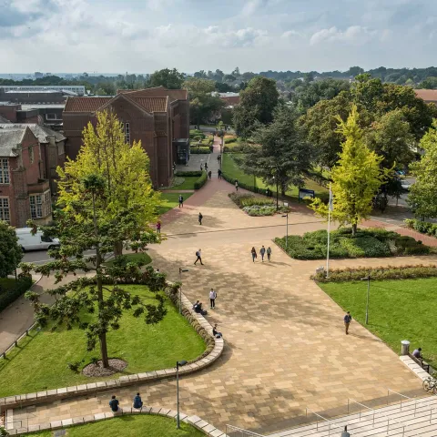 Aerial view of campus buildings, trees and courtyard area on a sunny day.