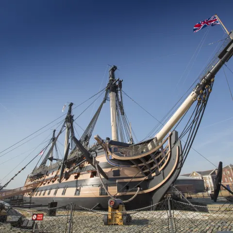 An exterior view of HMS Victory docked at Portsmouth Historic Dockyard.