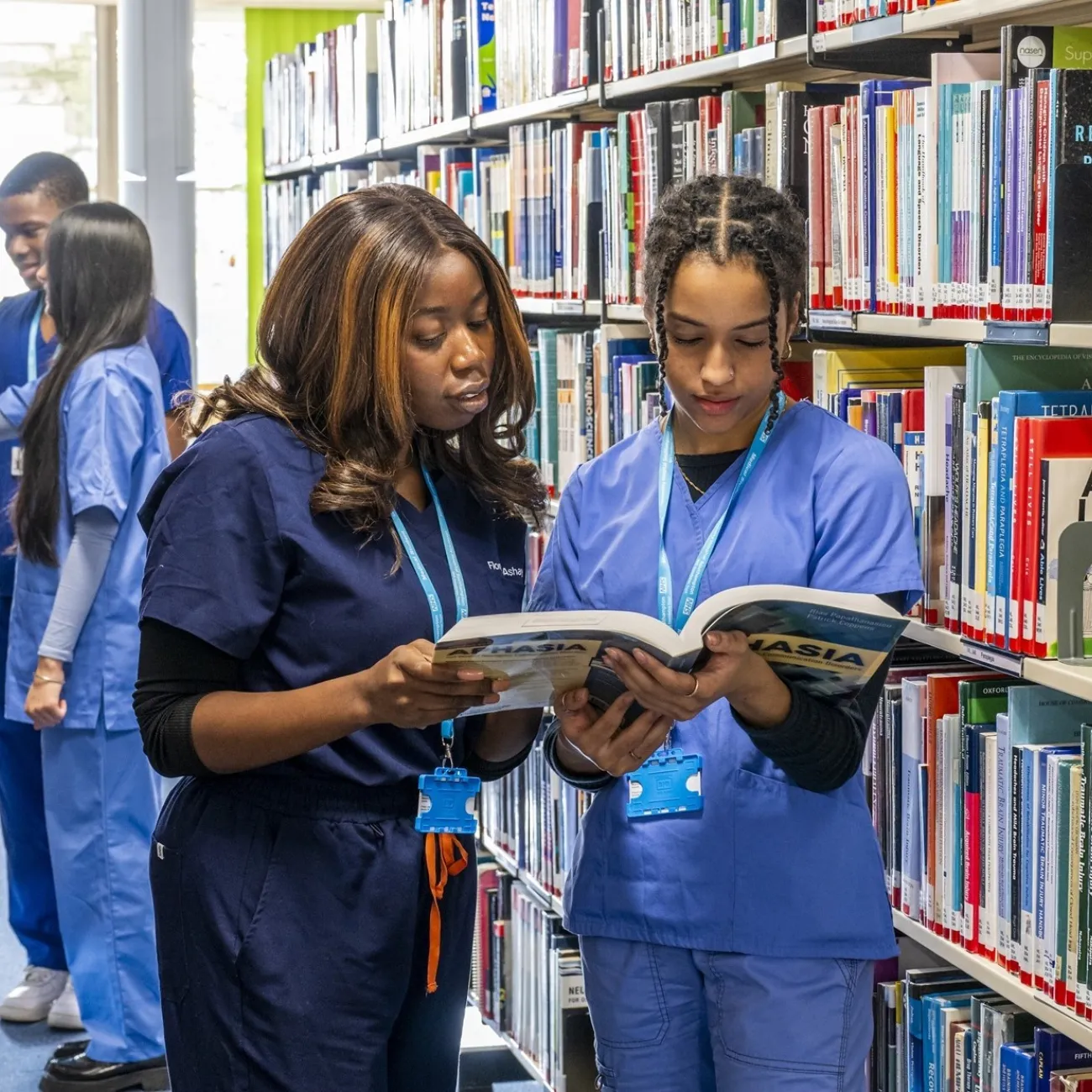 Medicine students consult text books in the Health Services library