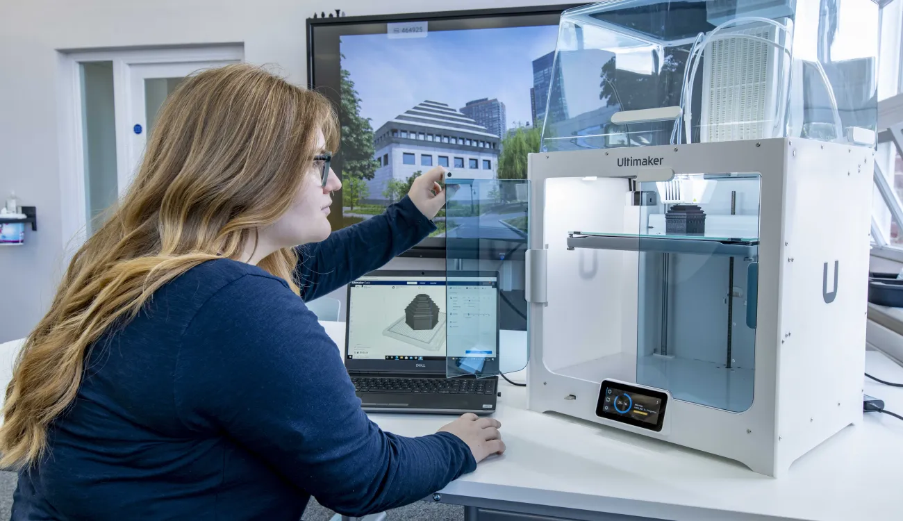 A student inspecting the finished construction of her latest 3D printed object.