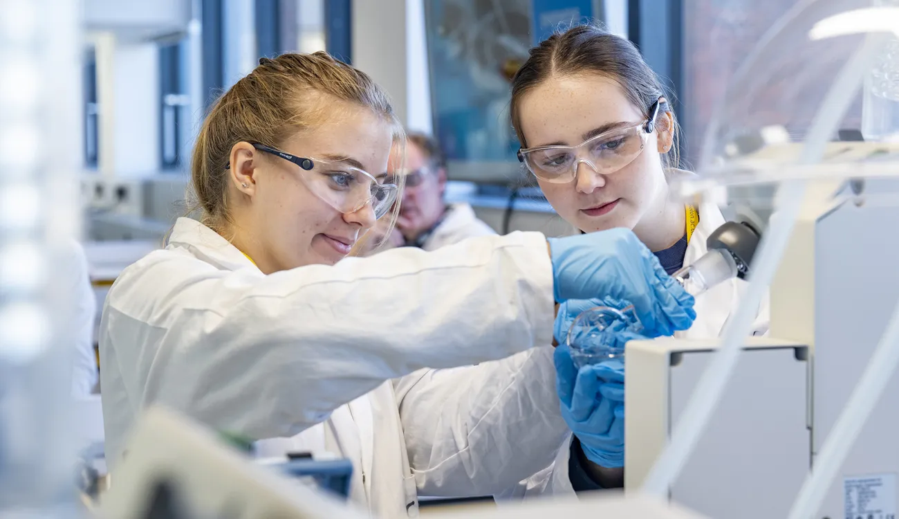 Working in a chemistry lab, an undergraduate uses a rotary evaporator to remove solvent from their sample.