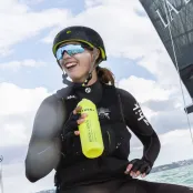 Hattie smiles happily, sailing in full gear in gentle waves