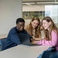 Marketing students gathered round a laptop