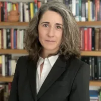  Dr Ainhoa Campas Velasco facing camera, standing in front of bookshelves